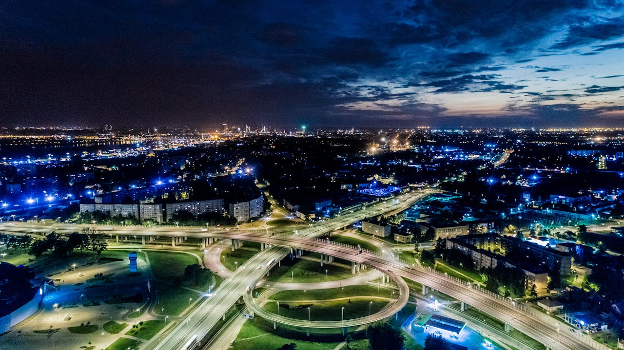 Mastering the First Impression: Your intriguing post title goes here Vibrant cityscape aerial view of illuminated highways and urban skyline at twilight.